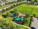 Aerial view of a neighborhood playground featuring modern play equipment and shaded seating areas at 337 Meadow Pointe Dr, Haines City, FL 33844
