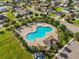 Aerial view of a large community pool with palm trees, lounge chairs, and covered seating area at 337 Meadow Pointe Dr, Haines City, FL 33844