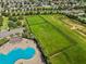 Aerial view of a community area with a pool, green space, and playground for active residents at 337 Meadow Pointe Dr, Haines City, FL 33844