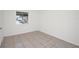 Neutral-toned bedroom featuring tile floors and a window letting in natural light at 4403 S Semoran Blvd # 3, Orlando, FL 32822