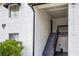 Exterior view of the condo building entrance, featuring a staircase and well-maintained landscaping at 4403 S Semoran Blvd # 3, Orlando, FL 32822