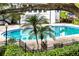 View of the community pool area with palm trees and lush landscaping at 4403 S Semoran Blvd # 3, Orlando, FL 32822