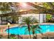 View of the community pool area with palm trees and lush landscaping at 4403 S Semoran Blvd # 3, Orlando, FL 32822