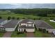 Aerial view of a home backing up to a large green space, surrounded by mature trees and other houses at 565 Ogelthorpe Dr, Davenport, FL 33897