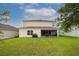 Spacious backyard with lush green grass and a screened-in patio area at 565 Ogelthorpe Dr, Davenport, FL 33897