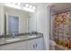 Well-lit bathroom featuring double sinks, a vanity with granite counters, and a shower with unique shower curtain at 565 Ogelthorpe Dr, Davenport, FL 33897