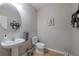 Half bath with a pedestal sink, round mirror, and modern decor at 565 Ogelthorpe Dr, Davenport, FL 33897