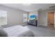 Bright bedroom features a sleek dresser with a TV and relaxing views, complemented by natural light at 565 Ogelthorpe Dr, Davenport, FL 33897