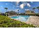 Community pool surrounded by a brick patio, lounge chairs, and lush greenery, perfect for relaxation at 565 Ogelthorpe Dr, Davenport, FL 33897