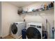 Modern laundry room features a front-load washer and dryer, with shelving for storage, and easy access at 565 Ogelthorpe Dr, Davenport, FL 33897