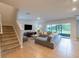 Open-concept living space with staircase, gray sectional sofa, and sliding doors to the lanai at 565 Ogelthorpe Dr, Davenport, FL 33897