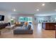 Spacious living room with gray sectional, tile floors, and sliding glass doors to screened lanai at 565 Ogelthorpe Dr, Davenport, FL 33897