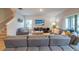 Bright living room with gray sectional sofa, flat-screen TV, and sliding glass doors to the outdoor area at 565 Ogelthorpe Dr, Davenport, FL 33897