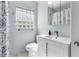 Bright bathroom with a modern white vanity, sleek fixtures, and a glass-block window for privacy and natural light at 600 Sheridan Blvd, Orlando, FL 32804