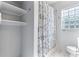 Cozy bathroom featuring a classic blue and white shower curtain, glass block window, and built-in storage shelves at 600 Sheridan Blvd, Orlando, FL 32804