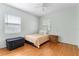 Bright bedroom with hardwood floors, a cozy twin bed, and natural light streaming in from two windows at 600 Sheridan Blvd, Orlando, FL 32804