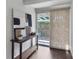 Inviting entryway featuring a modern console table with abstract art, leading to a sliding glass door to a brick-paved outdoor space at 600 Sheridan Blvd, Orlando, FL 32804