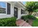 Inviting front entrance with brick steps, decorative door, manicured hedges, and blooming shrubs creating a warm welcome at 600 Sheridan Blvd, Orlando, FL 32804