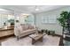 Bright living room with modern sofa, light walls, stylish coffee table, and a glimpse of the adjacent kitchen and dining area at 600 Sheridan Blvd, Orlando, FL 32804