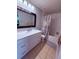 Bathroom featuring a large vanity, framed mirror, and a bathtub with a shower and decorative curtain at 6013 Scotchwood Gln # 20, Orlando, FL 32822