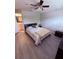 Comfortable bedroom with neutral paint, wood laminate flooring, and access to the bathroom at 6013 Scotchwood Gln # 20, Orlando, FL 32822