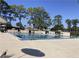 Community pool with sun umbrellas and lounge seating at 6013 Scotchwood Gln # 20, Orlando, FL 32822