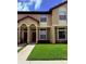 Attractive two-story townhome featuring manicured lawn and charming architectural details at 6013 Scotchwood Gln # 20, Orlando, FL 32822