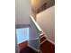 View of the staircase featuring dark wood floors, white railings, and light gray walls at 6013 Scotchwood Gln # 20, Orlando, FL 32822