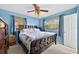 Comfortable bedroom features a ceiling fan, large windows, and neutral blue walls at 6430 Yellowstone St, Orlando, FL 32807