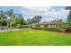 Single-story home with mature trees, lush green lawn, and manicured hedges adding curb appeal at 6430 Yellowstone St, Orlando, FL 32807
