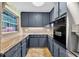 Well-lit kitchen featuring gray cabinets, stone countertops, and tile flooring at 6430 Yellowstone St, Orlando, FL 32807