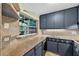 Kitchen features gray cabinets, stone countertops, and a view to the outside through a window at 6430 Yellowstone St, Orlando, FL 32807