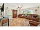Comfortable living room featuring tile flooring, a ceiling fan, and natural light from a large window at 6430 Yellowstone St, Orlando, FL 32807