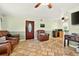Spacious living room with tile flooring, a ceiling fan, and a comfortable leather recliner at 6430 Yellowstone St, Orlando, FL 32807