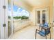 Outdoor balcony with two chairs overlooks green spaces, blue sky, and decorative white banister at 7398 Gathering Ct, Reunion, FL 34747