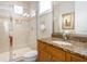 Bathroom with glass shower, granite counters, wooden cabinets, and a mounted towel rack at 7398 Gathering Ct, Reunion, FL 34747