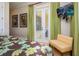 Bedroom features comfy sitting area, palm tree artwork, and sliding glass doors to a private balcony at 7398 Gathering Ct, Reunion, FL 34747