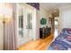 Bright bedroom features light wood floors, TV, dresser, and patio access with curtains to block the light at 7398 Gathering Ct, Reunion, FL 34747