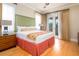 Comfortable bedroom boasts a king-size bed, wood flooring, ceiling fan, and private balcony access at 7398 Gathering Ct, Reunion, FL 34747