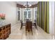 Formal dining room with a glass table, tile floors, and a large bay window at 7398 Gathering Ct, Reunion, FL 34747