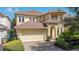 Charming two-story home featuring a tile roof, brick driveway and two car garage at 7398 Gathering Ct, Reunion, FL 34747