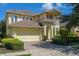 Charming two-story home with a two-car garage, balcony, and manicured landscaping at 7398 Gathering Ct, Reunion, FL 34747