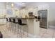 Open concept kitchen with bar seating and stainless steel appliances and a granite countertop at 7398 Gathering Ct, Reunion, FL 34747