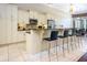 Open kitchen with white cabinetry, stainless steel appliances, and bar seating at 7398 Gathering Ct, Reunion, FL 34747