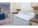 Bright laundry room features modern washer and dryer, granite countertop and cabinetry with storage at 7398 Gathering Ct, Reunion, FL 34747