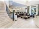 Open-concept living room showcasing a staircase, kitchen, and outdoor dining area with water view at 7398 Gathering Ct, Reunion, FL 34747