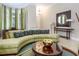 Elegant living room featuring a curved sofa, stylish mirror and decor, and arched windows at 7398 Gathering Ct, Reunion, FL 34747