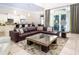 Spacious living room with a comfortable leather sofa, modern coffee table, and access to outdoor pool area at 7398 Gathering Ct, Reunion, FL 34747
