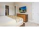 Spacious bedroom with a dresser and tv, ensuite bathroom, and bright natural light at 7398 Gathering Ct, Reunion, FL 34747