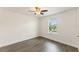 Bright bedroom with gray wood floors, ceiling fan, and a sunny window view at 7816 Winter Wren St, Winter Garden, FL 34787